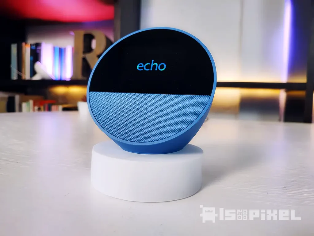 Amazon Echo Spot (2024) mostrando la hora y el clima en una mesita de noche junto a una taza de café.