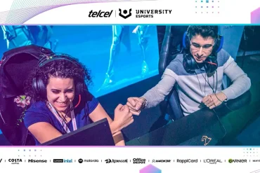 Estudiantes universitarios compitiendo en un torneo de esports con pantallas y controles en un escenario profesional.