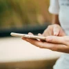 Primer plano de una persona sosteniendo un smartphone y navegando en la pantalla, representando el uso cotidiano de dispositivos móviles y la vulnerabilidad ante ciberataques.