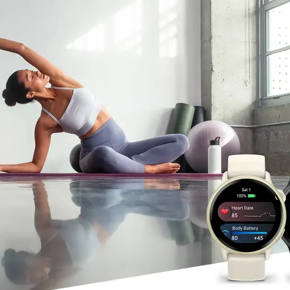 Mujer practicando yoga junto al smartwatch Garmin vívoactive 6 en colores hueso y negro.