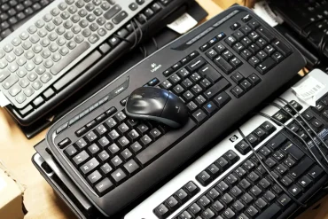 Teclados y mouse usados, apilados como parte de un programa de reciclaje electrónico. Logitech y Lumen incentivan la entrega de estos dispositivos para fomentar la economía circular en México mediante descuentos en nuevos productos.