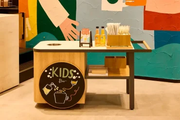 Estación interactiva “Kids Bar” en el nuevo café infantil de Starbucks en Osaka, equipada con toppings, jarabes y utensilios para que los niños personalicen sus bebidas en un entorno seguro y adaptado a sus necesidades.