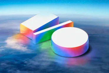 Logo tridimensional de Google I/O 2025 flotando sobre un cielo con nubes, en colores iridiscentes que simbolizan tecnología e innovación.