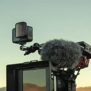 GoPro HERO13 Black con lente anamórfico montada sobre rig profesional con micrófono externo y monitor en paisaje abierto.