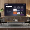 Sala moderna con un televisor Roku TV encendido mostrando las aplicaciones de streaming como Netflix, Disney+, ViX, Roku Channel y Apple TV.