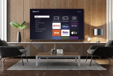 Sala moderna con un televisor Roku TV encendido mostrando las aplicaciones de streaming como Netflix, Disney+, ViX, Roku Channel y Apple TV.