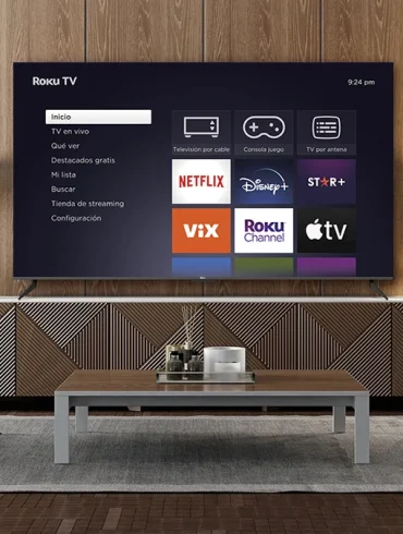 Sala moderna con un televisor Roku TV encendido mostrando las aplicaciones de streaming como Netflix, Disney+, ViX, Roku Channel y Apple TV.