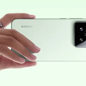 Primer plano del Xiaomi 15 en color verde claro, sostenido en posición horizontal por una mano. Se destaca el módulo de triple cámara con lentes Leica, que refleja la apuesta de la marca por la fotografía móvil profesional y el diseño minimalista.