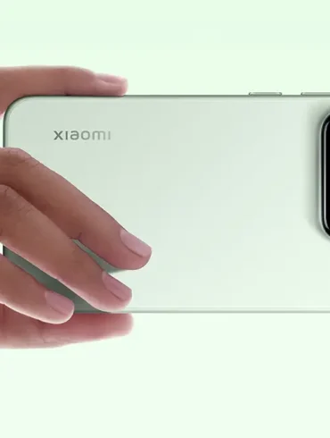 Primer plano del Xiaomi 15 en color verde claro, sostenido en posición horizontal por una mano. Se destaca el módulo de triple cámara con lentes Leica, que refleja la apuesta de la marca por la fotografía móvil profesional y el diseño minimalista.
