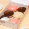 Caja de donas edición limitada de Krispy Kreme inspiradas en sabores de cheesecake, con coberturas de fresa, chocolate, galleta y cookies & cream.