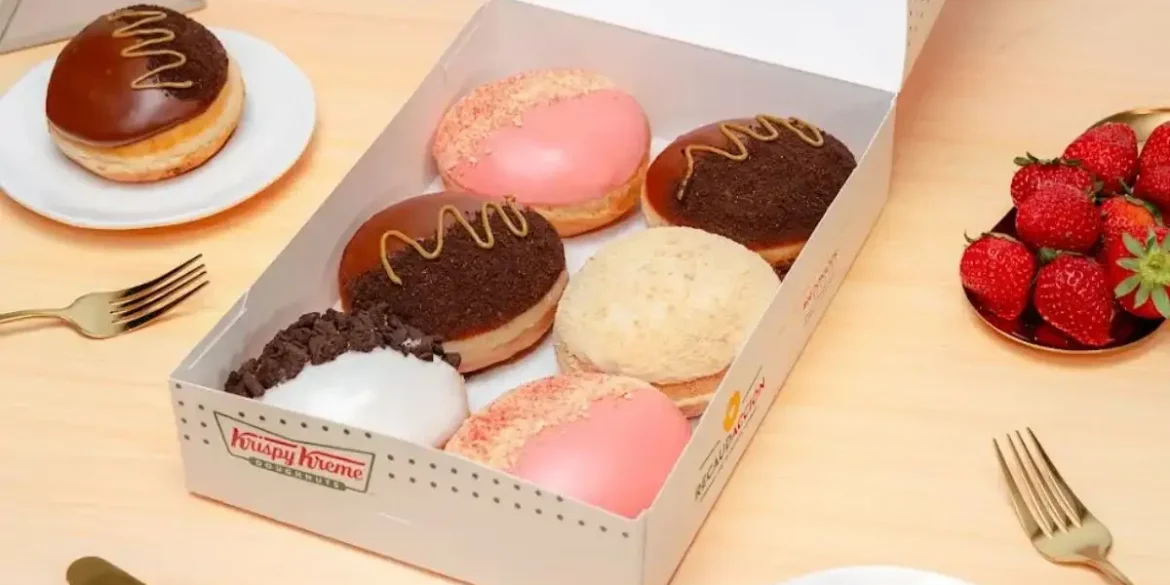 Caja de donas edición limitada de Krispy Kreme inspiradas en sabores de cheesecake, con coberturas de fresa, chocolate, galleta y cookies & cream.