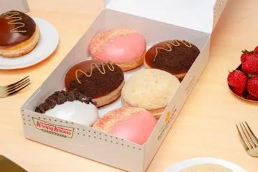 Caja de donas edición limitada de Krispy Kreme inspiradas en sabores de cheesecake, con coberturas de fresa, chocolate, galleta y cookies & cream.