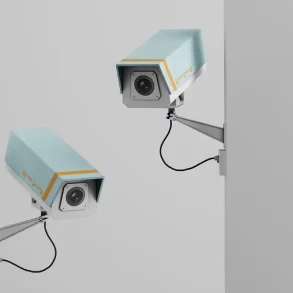 Dos cámaras de seguridad montadas en una pared vigilan en direcciones opuestas, simbolizando la vigilancia intramuros utilizada en negocios para prevenir robos sin violencia.