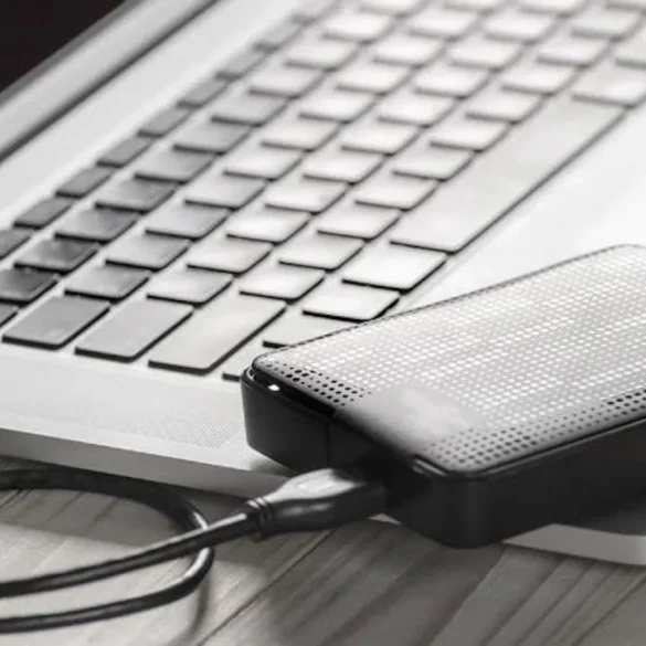 Disco duro externo conectado a una MacBook mediante cable USB