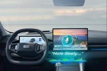 Interior del Geely EX5 mostrando pantalla central con comando de voz activo y volante digitalizado.