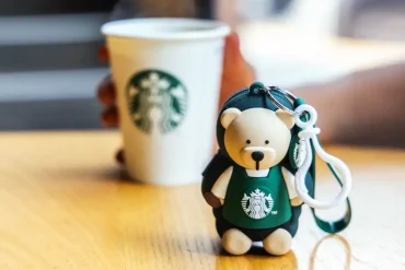 Llavero barista edición especial de Starbucks México 2025 junto a un café, símbolo de la campaña “Todos Sembramos Café”.
