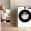 Pareja controlando lavadora LG ThinQ AI desde smartphone con notificación inteligente