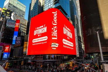Pantalla gigante de LG en Times Square promociona Radio Optimism, la campaña global que permite crear canciones personalizadas con inteligencia artificial.