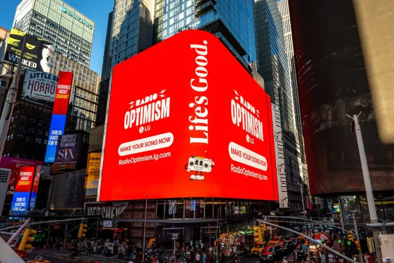 Pantalla gigante de LG en Times Square promociona Radio Optimism, la campaña global que permite crear canciones personalizadas con inteligencia artificial.