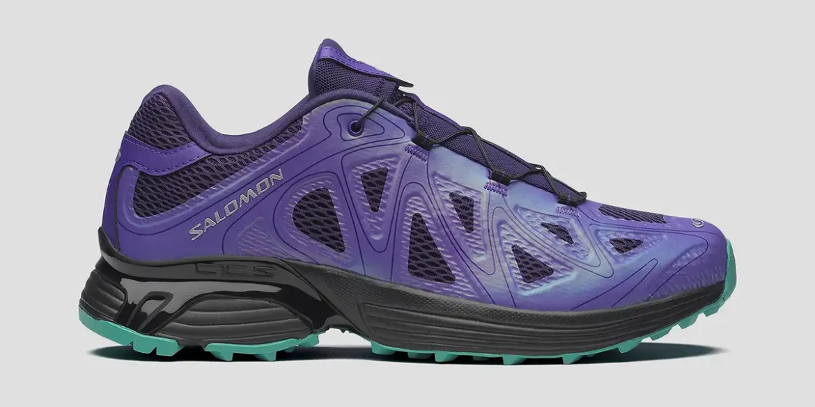 Tenis Salomon XT-Whisper Void en color púrpura y verde menta, con diseño técnico de trail running y detalles iridiscentes exhibidos en TAF.