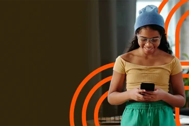 Mujer consulta su smartphone junto a un gráfico de señal Wi-Fi, imagen de Aprecomm sobre conectividad inteligente con IA